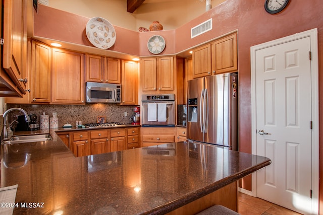 kitchen featuring kitchen peninsula, backsplash, stainless steel appliances, sink, and light tile patterned flooring