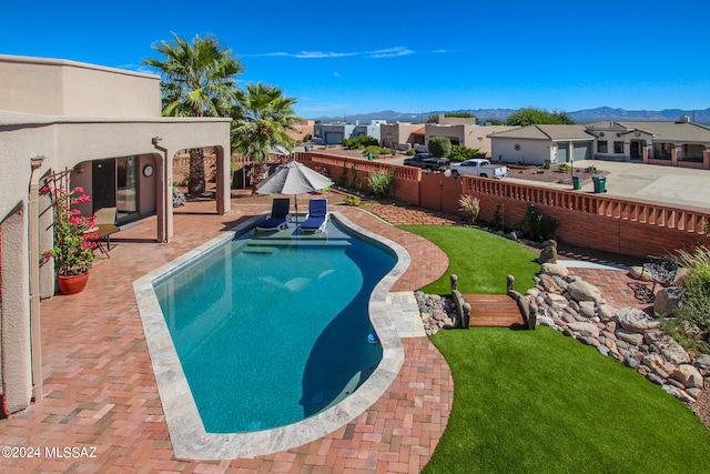 view of swimming pool featuring a patio and a lawn