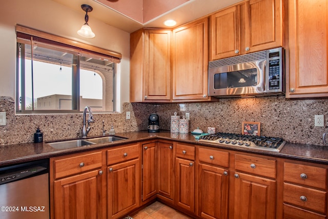 kitchen with decorative backsplash, appliances with stainless steel finishes, sink, decorative light fixtures, and light tile patterned flooring