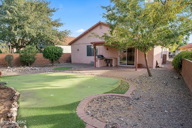 rear view of house with a patio and exterior kitchen