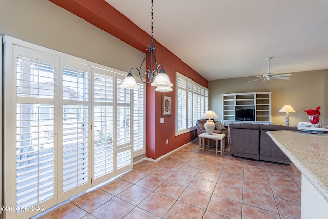 interior space with ceiling fan with notable chandelier and plenty of natural light