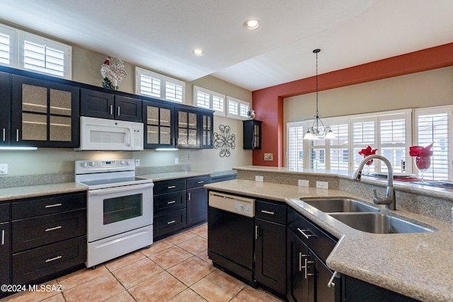 kitchen featuring white appliances, sink, plenty of natural light, and hanging light fixtures