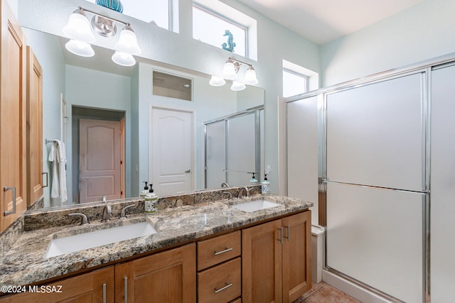 bathroom featuring a shower with door and vanity