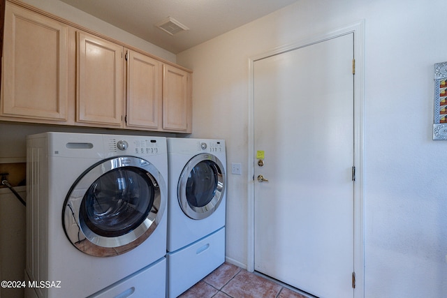 laundry area with light tile patterned floors, cabinets, and separate washer and dryer