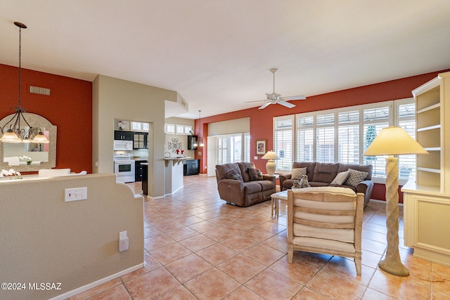 living room with ceiling fan with notable chandelier and light tile patterned floors