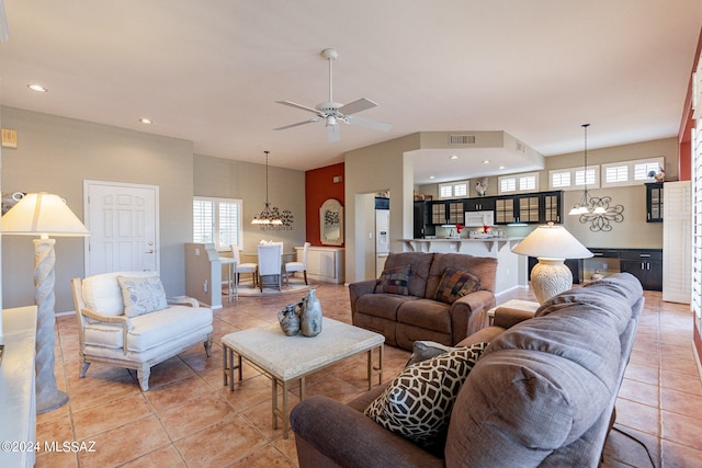 tiled living room with a healthy amount of sunlight and ceiling fan with notable chandelier