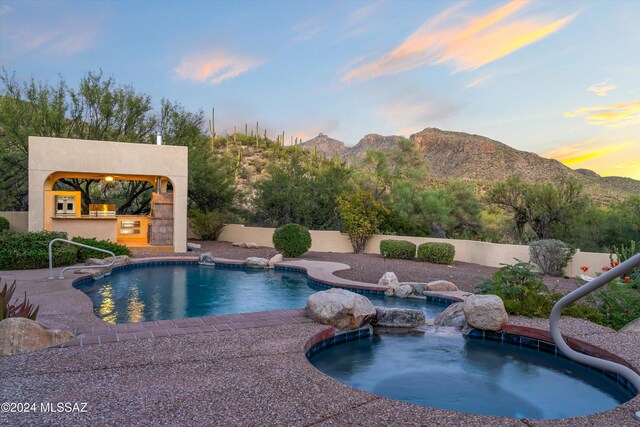 pool at dusk featuring a patio area and a mountain view