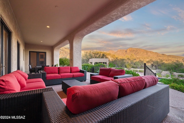 patio terrace at dusk featuring an outdoor living space and a mountain view