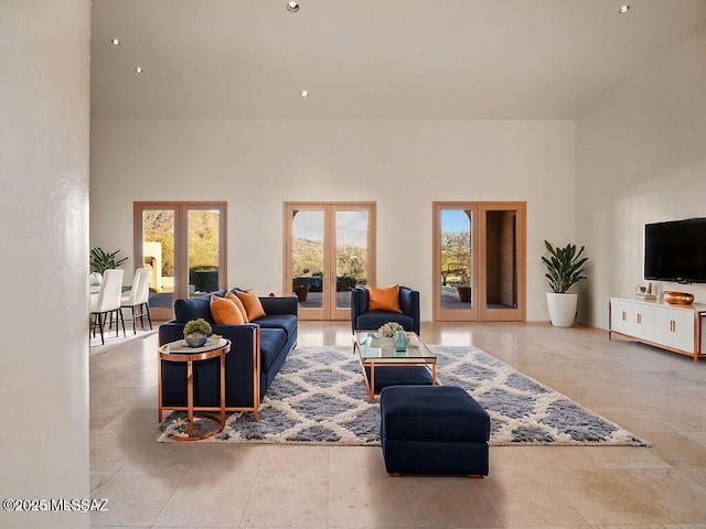 living room featuring a high ceiling, light tile patterned flooring, and french doors