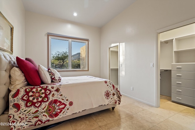 tiled bedroom with a walk in closet and a closet