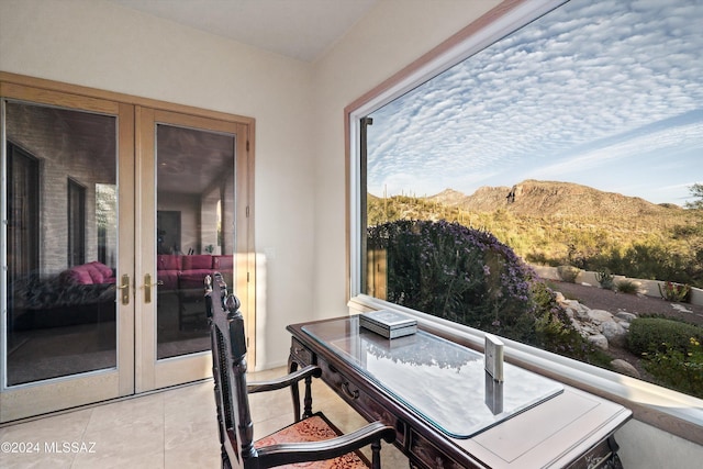 interior space with a balcony, a mountain view, and french doors