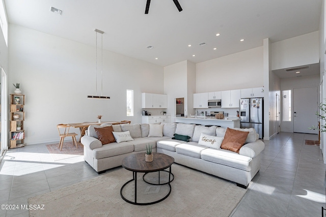 living room with light tile patterned flooring and a high ceiling