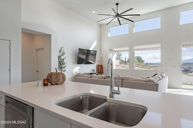 kitchen with white cabinetry, light tile patterned floors, washing machine and dryer, and a high ceiling