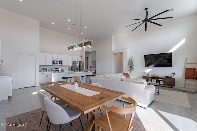 dining space featuring recessed lighting, ceiling fan, a high ceiling, and light tile patterned floors