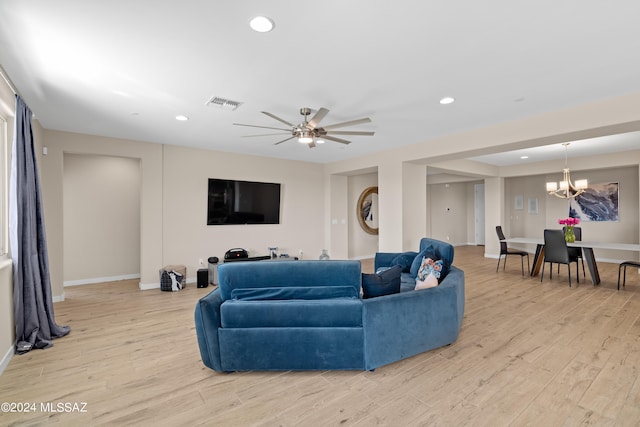 living room with light hardwood / wood-style flooring and ceiling fan with notable chandelier