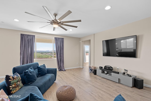 living room featuring ceiling fan and light hardwood / wood-style flooring