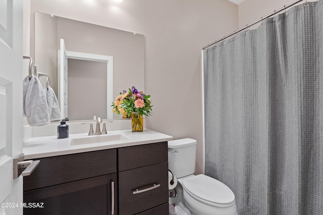 bathroom featuring vanity, walk in shower, and toilet