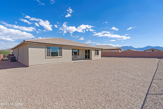 rear view of house featuring cooling unit, a mountain view, and a patio area