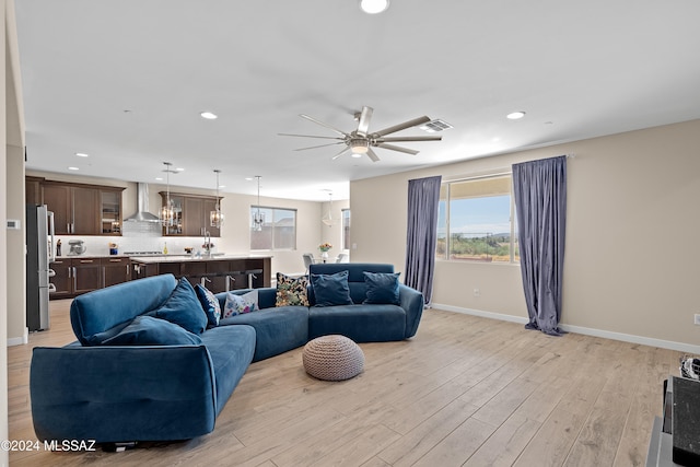 living room with light hardwood / wood-style flooring and ceiling fan