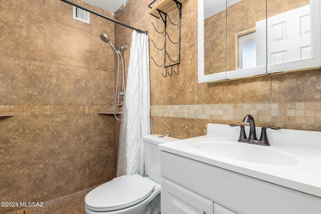 bathroom with vanity, curtained shower, toilet, and tile walls