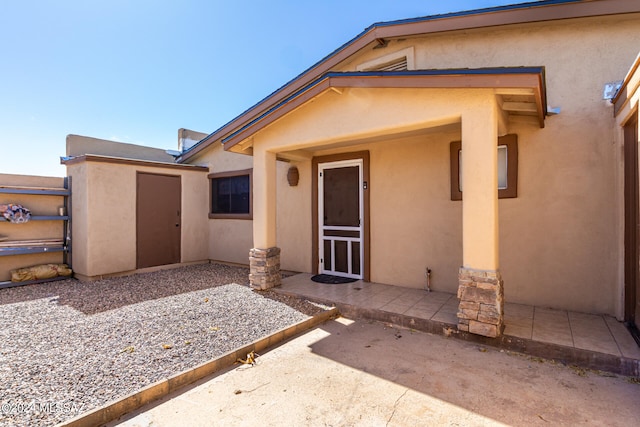 view of exterior entry featuring a patio area