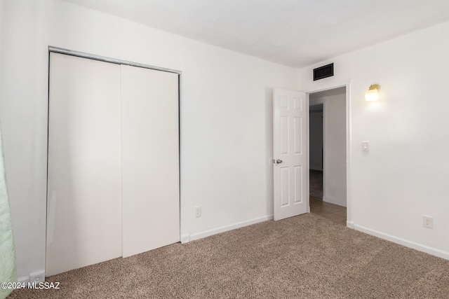 unfurnished bedroom featuring carpet and a closet