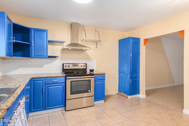 kitchen featuring blue cabinetry, wall chimney range hood, and electric range