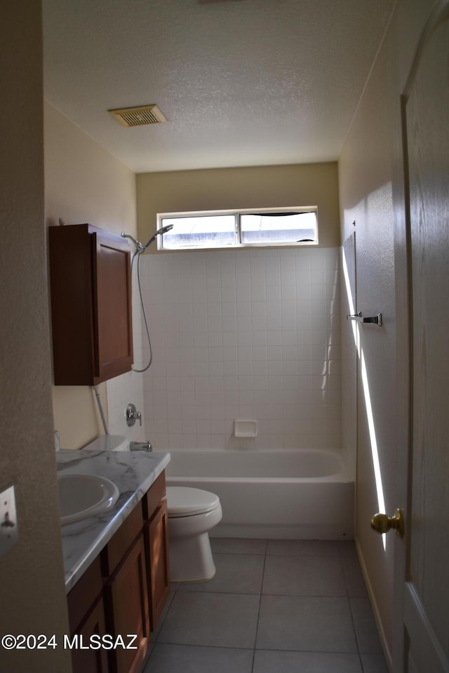 full bathroom with tile patterned floors, toilet, a textured ceiling, vanity, and tiled shower / bath combo