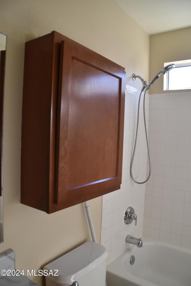 bathroom with tiled shower / bath and toilet