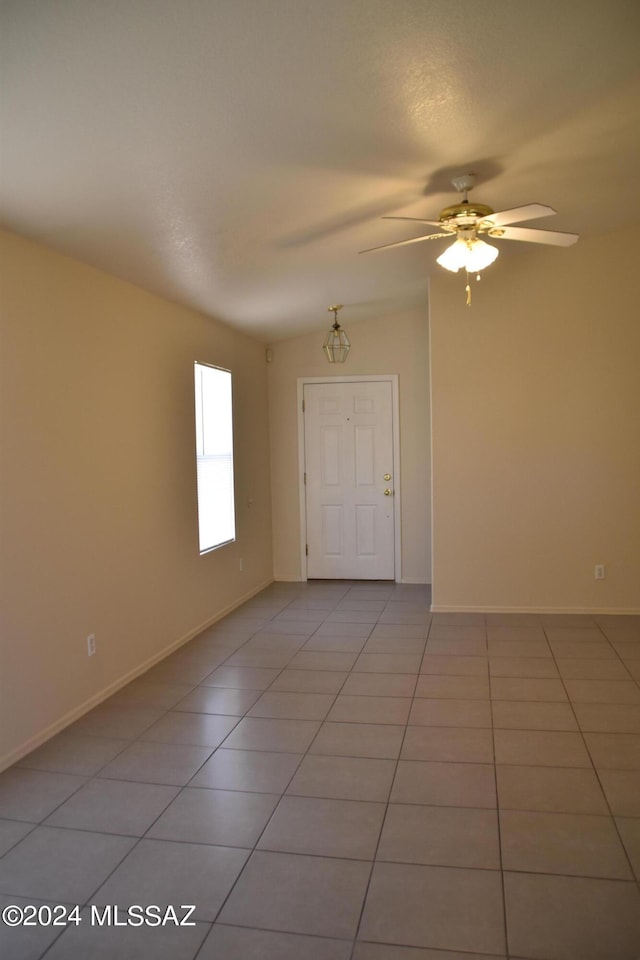 spare room with light tile patterned flooring, ceiling fan, and lofted ceiling