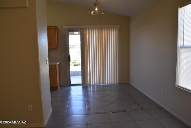 interior space with vaulted ceiling, light tile patterned flooring, and plenty of natural light