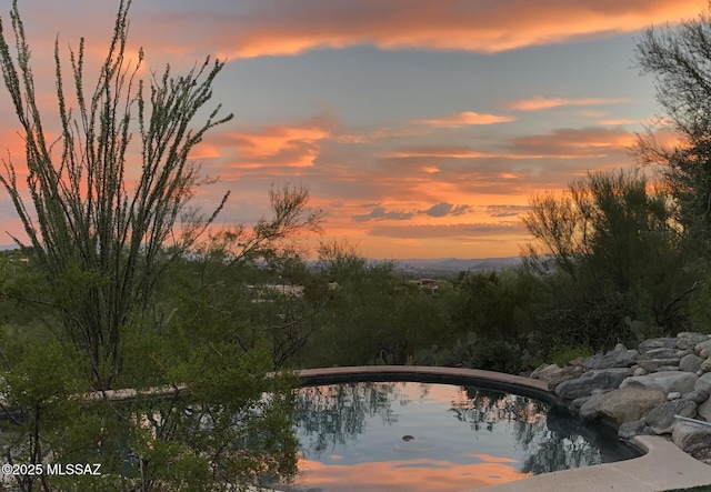 view of pool at dusk