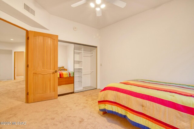 bedroom with ceiling fan, a closet, and light carpet