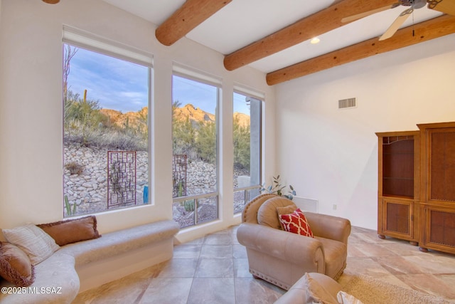 unfurnished living room featuring beamed ceiling, ceiling fan, and wooden ceiling