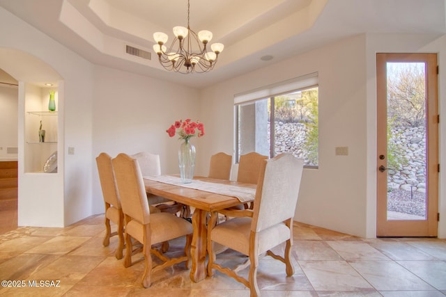 living room with beamed ceiling, a tray ceiling, light tile patterned flooring, and ceiling fan with notable chandelier