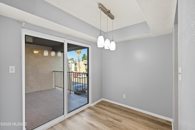 unfurnished dining area with an inviting chandelier and wood-type flooring