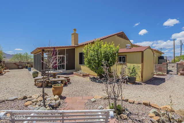 1888 Circulo Guatemala, Rio Rico, AZ 85648 - back of house featuring a sunroom, fence, a chimney, and a gate