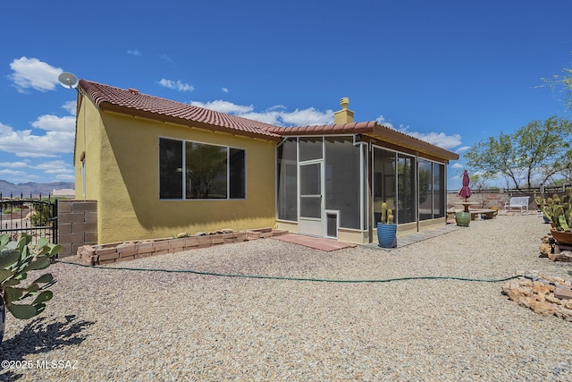 1888 Circulo Guatemala, Rio Rico, AZ 85648 - rear view of house with a sunroom, stucco siding, a tile roof, a chimney, and fence
