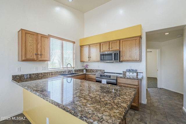 1888 Circulo Guatemala, Rio Rico, AZ 85648 - kitchen with appliances with stainless steel finishes, a sink, a towering ceiling, baseboards, and a peninsula