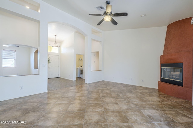 1888 Circulo Guatemala, Rio Rico, AZ 85648 - unfurnished living room featuring ceiling fan, washer and clothes dryer, and a fireplace