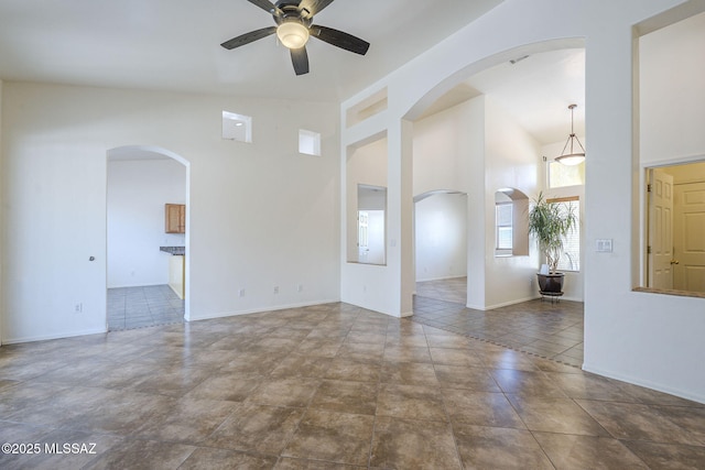 1888 Circulo Guatemala, Rio Rico, AZ 85648 - empty room featuring a ceiling fan, arched walkways, baseboards, and high vaulted ceiling
