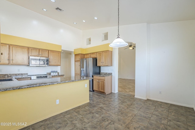 1888 Circulo Guatemala, Rio Rico, AZ 85648 - kitchen featuring appliances with stainless steel finishes, dark stone countertops, hanging light fixtures, baseboards, and a high ceiling