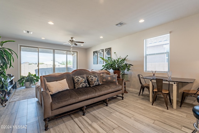 living room with ceiling fan and light hardwood / wood-style flooring