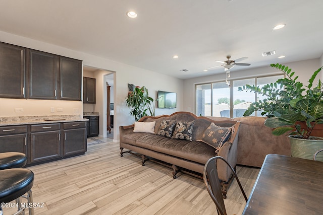 living room with light hardwood / wood-style floors and ceiling fan