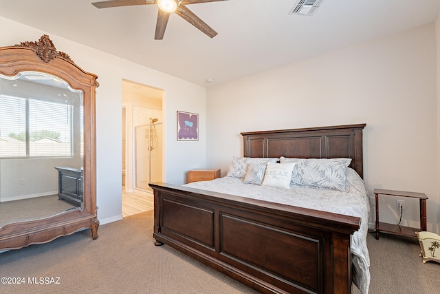 carpeted bedroom featuring ensuite bath and ceiling fan