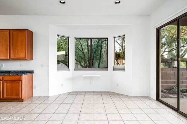 interior space with light tile patterned flooring and a healthy amount of sunlight