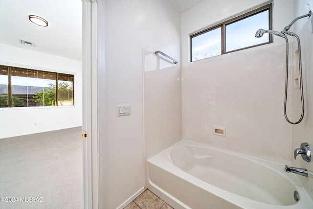 bathroom with tile patterned flooring, shower / bathing tub combination, and plenty of natural light