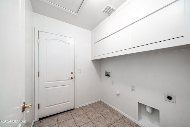 clothes washing area with electric dryer hookup, hookup for a washing machine, gas dryer hookup, light tile patterned floors, and cabinets