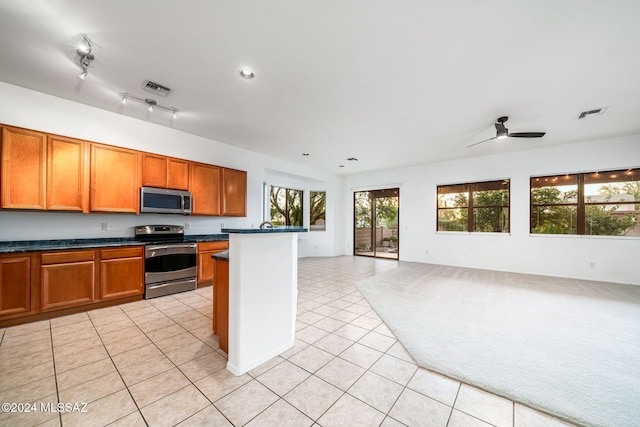 kitchen featuring appliances with stainless steel finishes, light tile patterned flooring, and ceiling fan