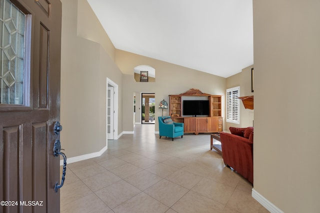 living room featuring high vaulted ceiling and light tile patterned floors